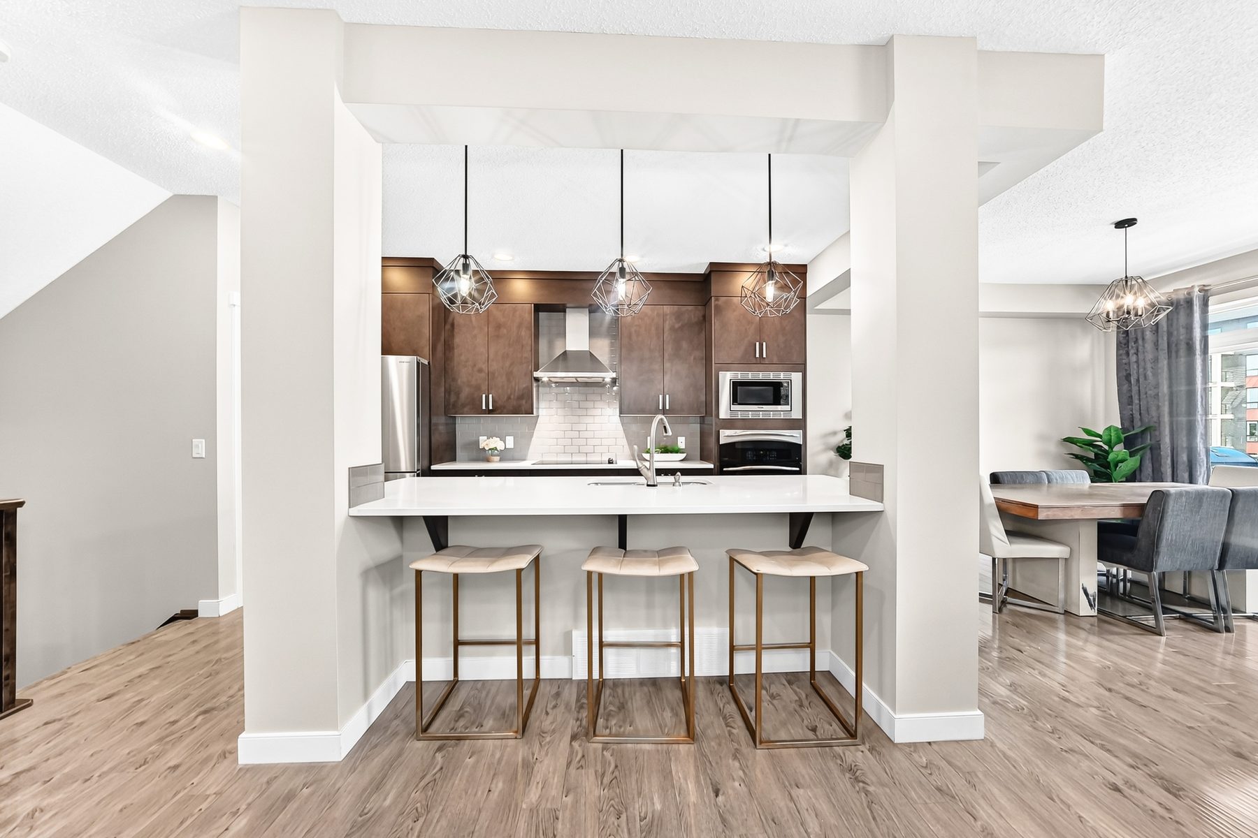 Living and dining area with hardwood floors and modern light fixtures